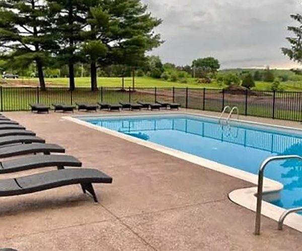 Outdoor swimming pool with lounge chairs at CreationView Campground in Michigan’s Irish Hills