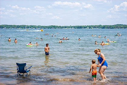 Families swimming and enjoying the beach at W.J. Hayes State Park on Wamplers Lake in Michigan