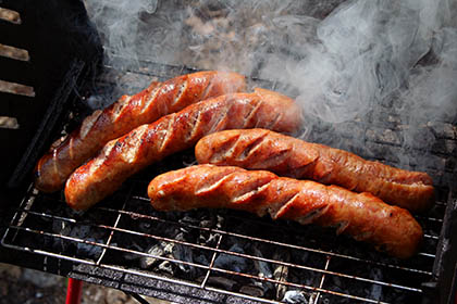 Smoked sausage cooking on a grill at West Texas Barbecue in the Irish Hills of Michigan